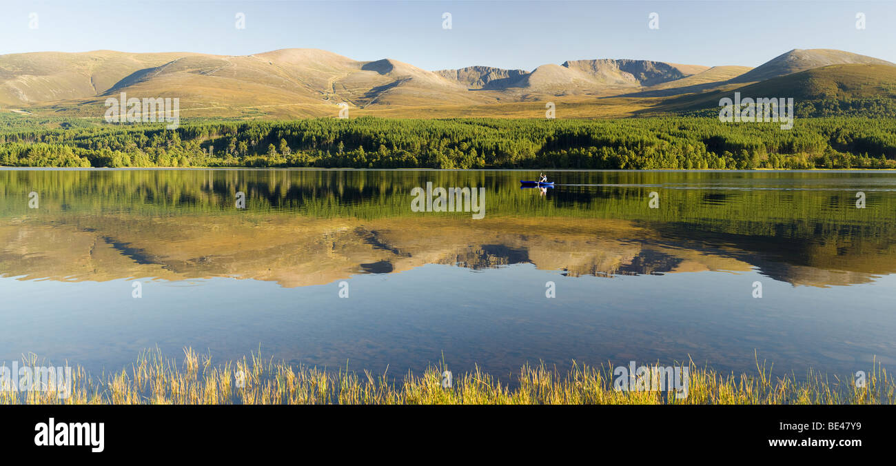 Canoeing on Loch Morlich, in Glen More, with reflections of the Cairngorms Stock Photo