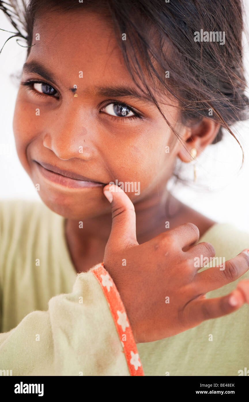 Happy Indian girl pretending to play the flute with her fingers. India Stock Photo