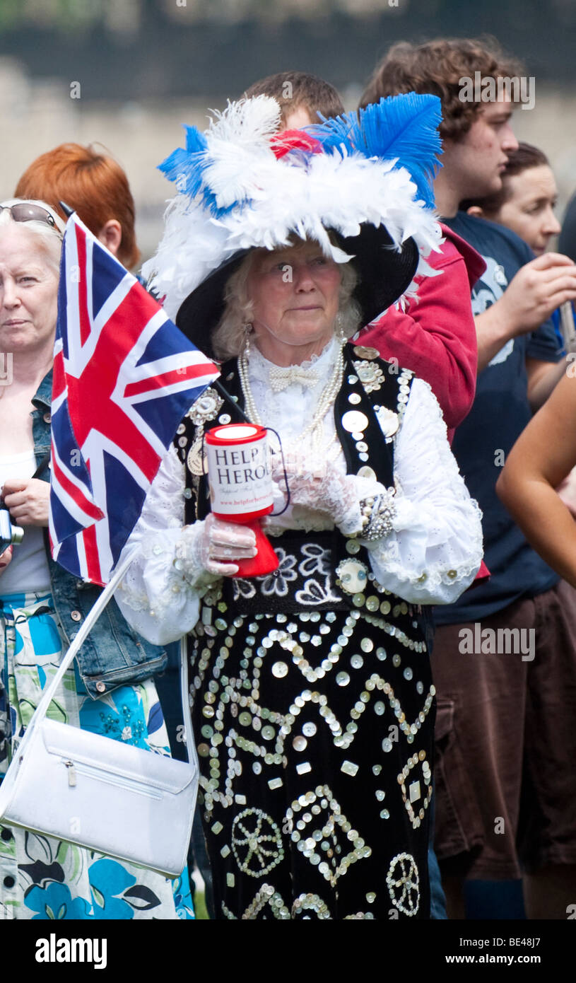 Woman dressed in traditional Pearly  Queen costume covered in mother-of-pearl buttons collecting money for 'Help heroes' charity Stock Photo