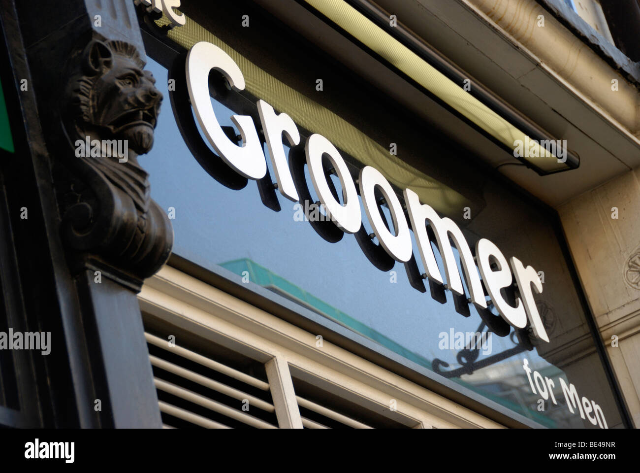 'Groomer for Men' sign outside barbers shop Stock Photo