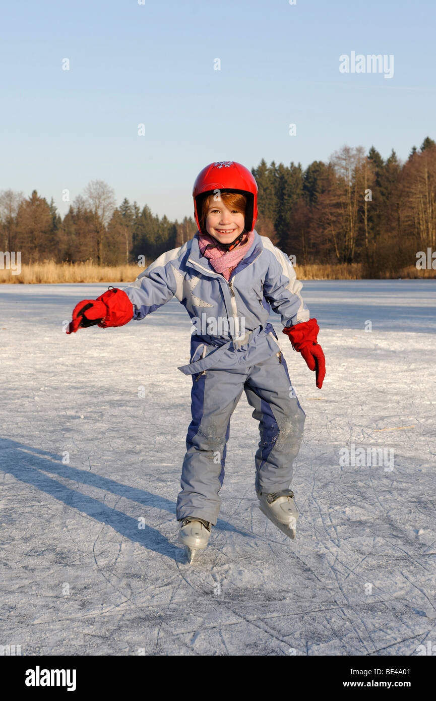 Girl wearing a helmet iceskating on a little lake Stock Photo Alamy