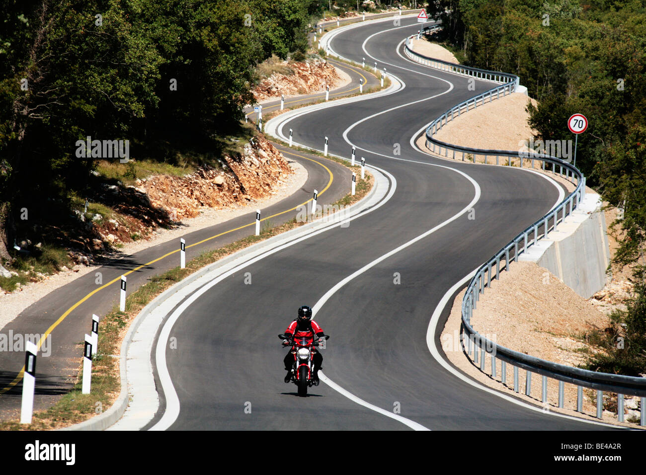 motorcyclist on winding road, krk island, croatia Stock Photo