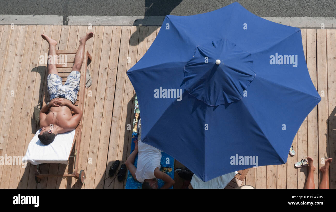 Sunbathing beneath an umbrella at Paris Plage Stock Photo