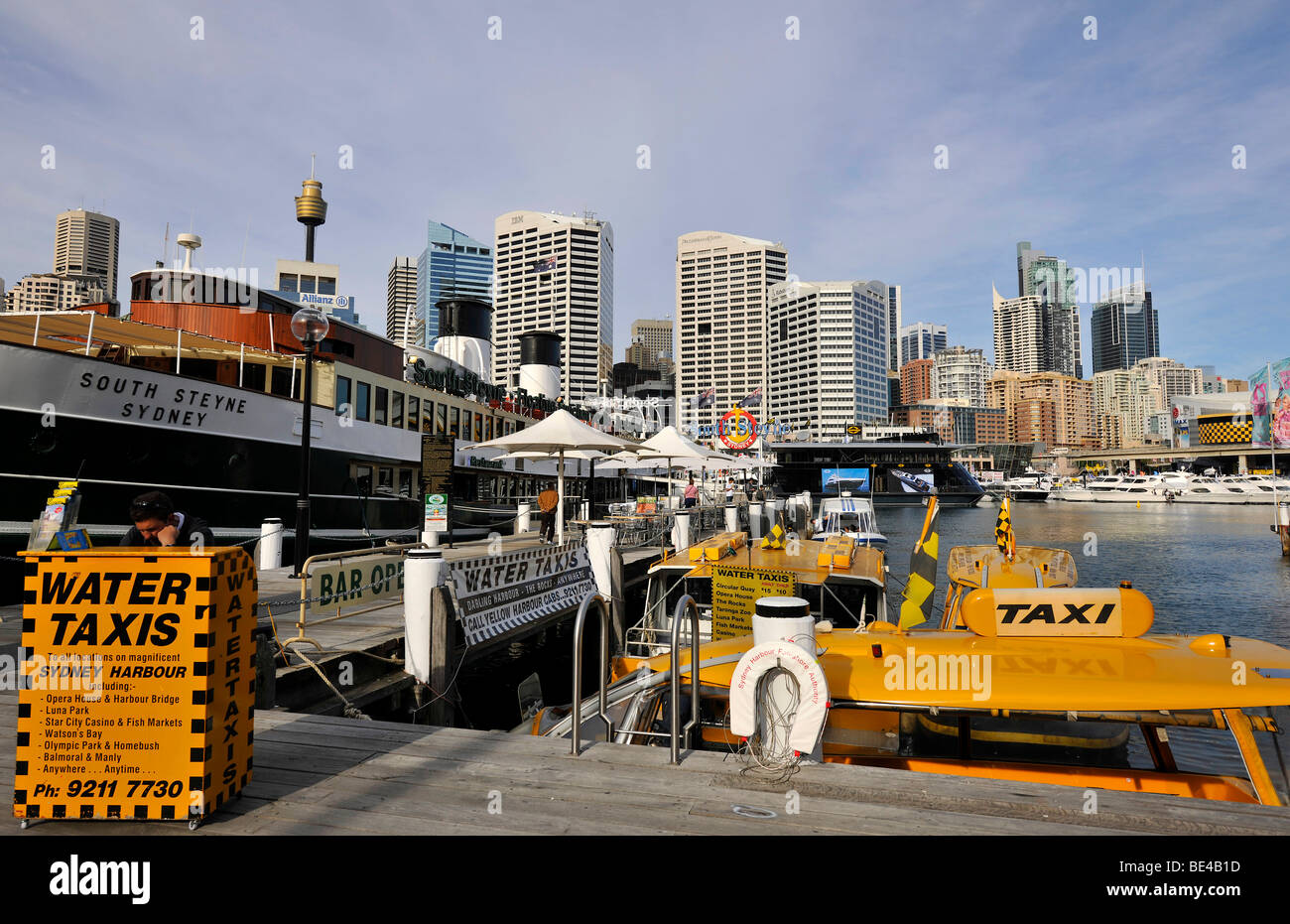 Water taxis in Darling Harbour in front of Sydney Tower or Centrepoint Tower and the skyline of the Central Business District,  Stock Photo