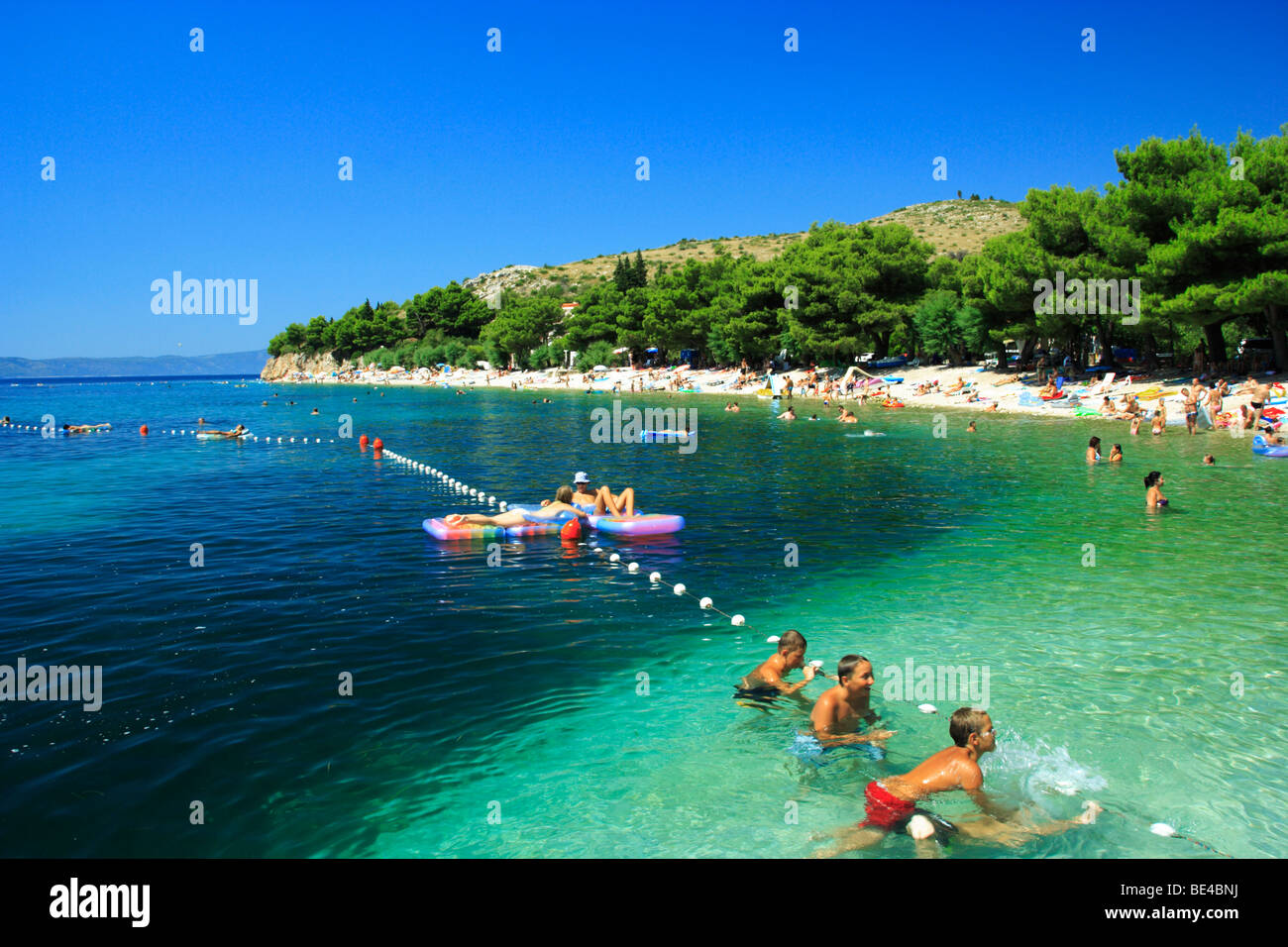 Tourists enjoying their time at a beach in Zivogosce village, Croatia Stock Photo