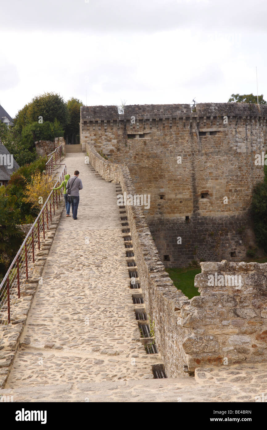 Two people walking along the city wall in Dinan France Stock Photo
