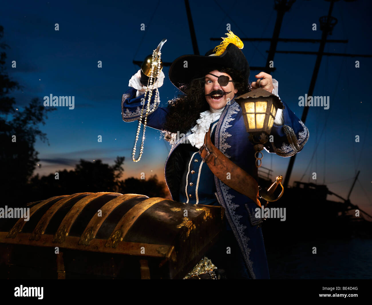 License available at MaximImages.com - Pirate with a lantern opening a treasure chest Stock Photo