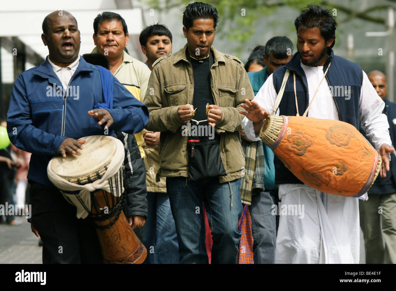 Hare Krishna devotees group walking chanting mantras drumming playing music at streets of Rotterdam Netherlands Stock Photo