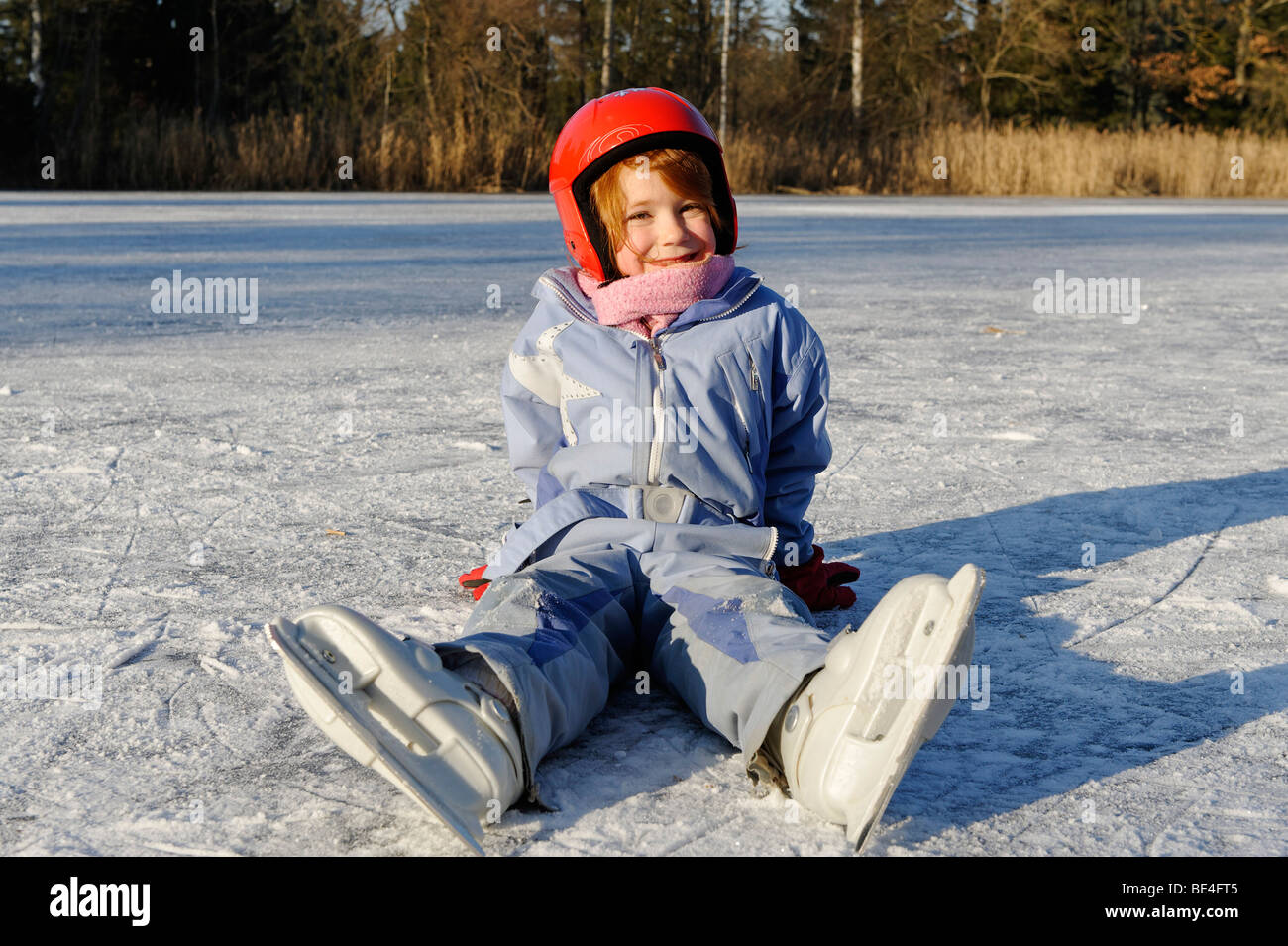 Girl wearing a helmet iceskating on a little lake Stock Photo Alamy