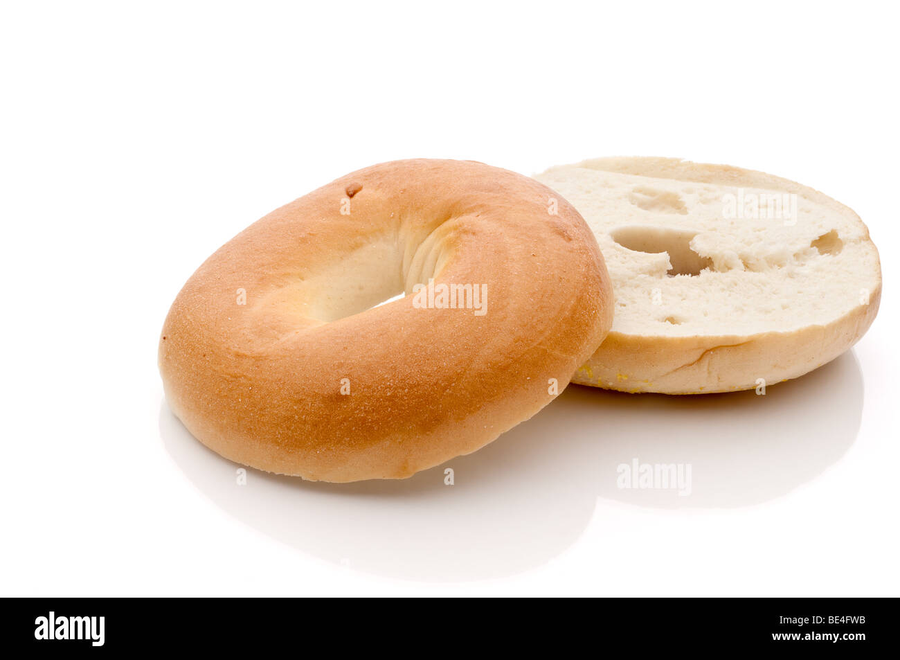 a horizontal sliced bagel on a white reflective surface Stock Photo