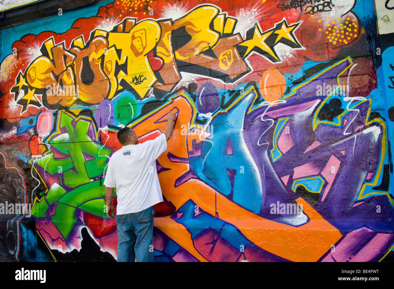 Graffiti artist works on his mural on the Five Pointz building in Long Island City in Queens Stock Photo