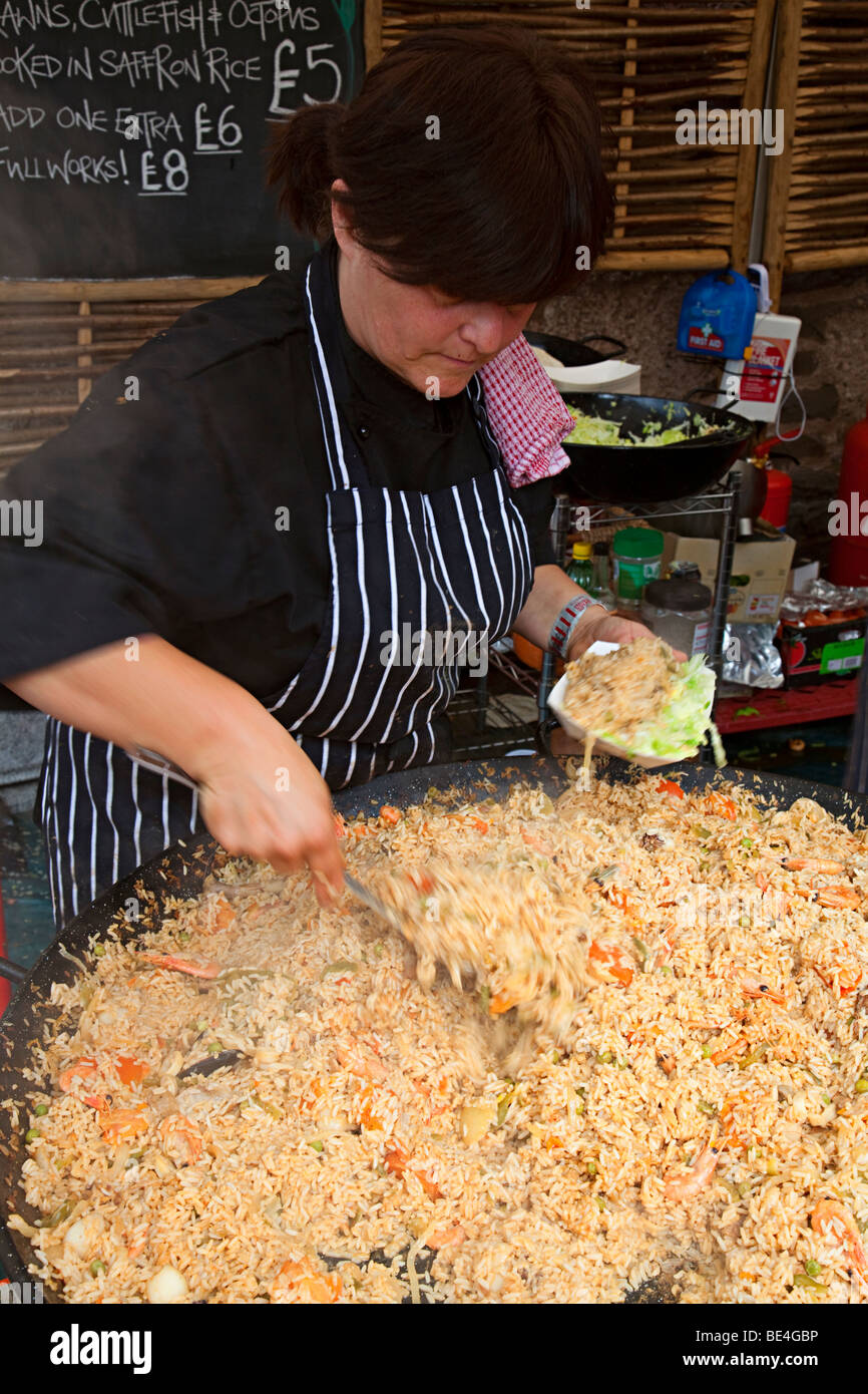 Serving paella on market stand Abergavenny food festival Wales UK Stock Photo