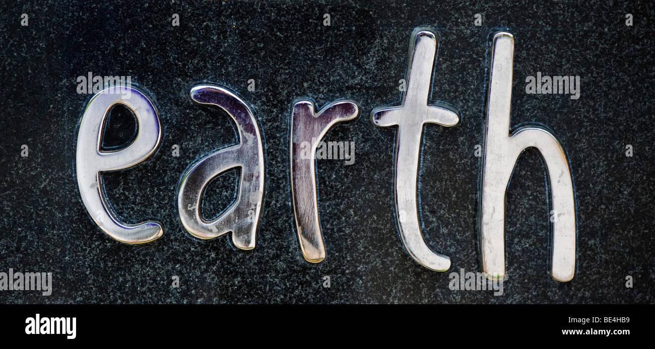The word EARTH on a stone plaque in metal chrome Stock Photo Alamy