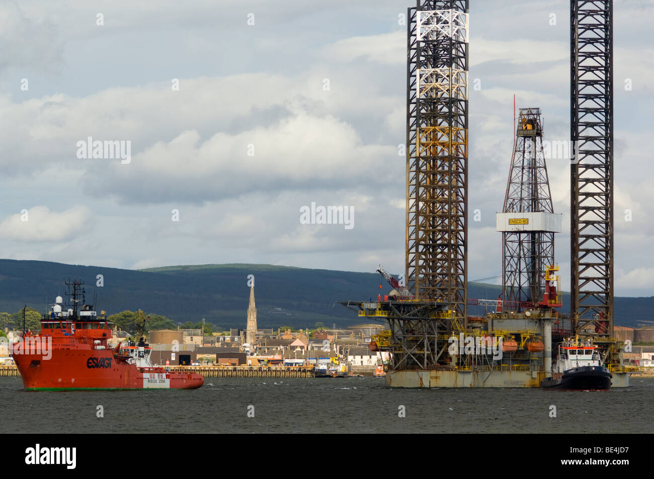 A jackup oil drilling rig, the Ensco 80, being towed up the Cromarty Firth, passing the town of Invergordon. Stock Photo