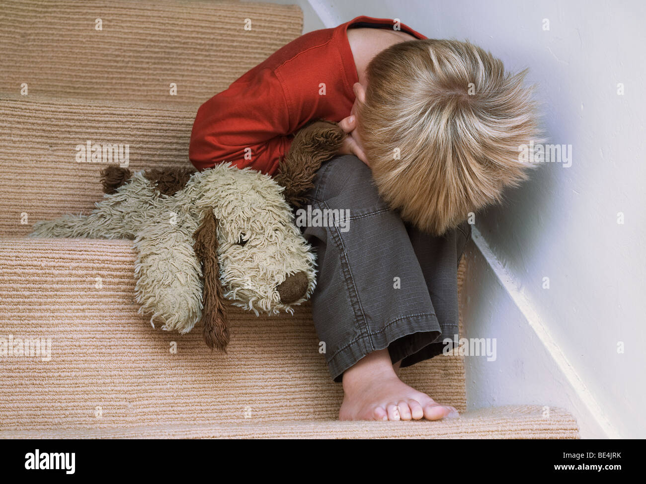 Concept of upset child with his toy dog. Stock Photo