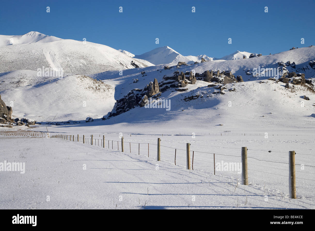 Farmland, Fenceline, Limestone Tors and Snow, Castle Hill, Arthur's Pass Road, Canterbury, South Island, New Zealand Stock Photo