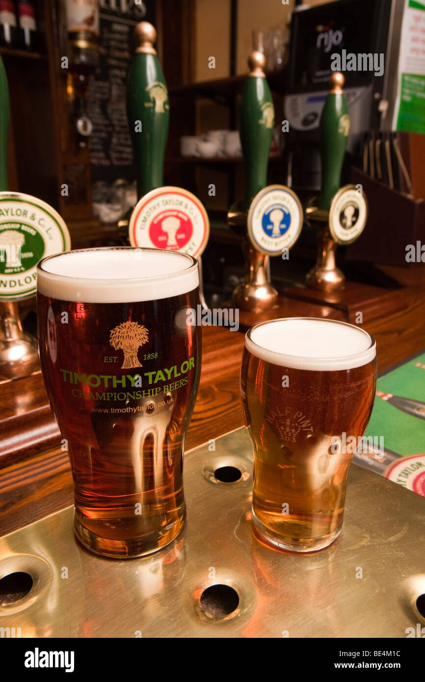 UK, England, Yorkshire, Haworth, Fleece Inn pint and half of locally brewed Timothy Taylors beer on bar Stock Photo