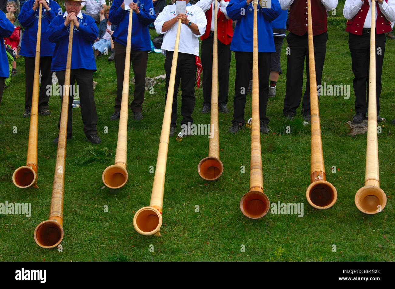 Alphorns, alphorn musician and spectators at a Swiss folk festival, Valais, Switzerland Stock Photo