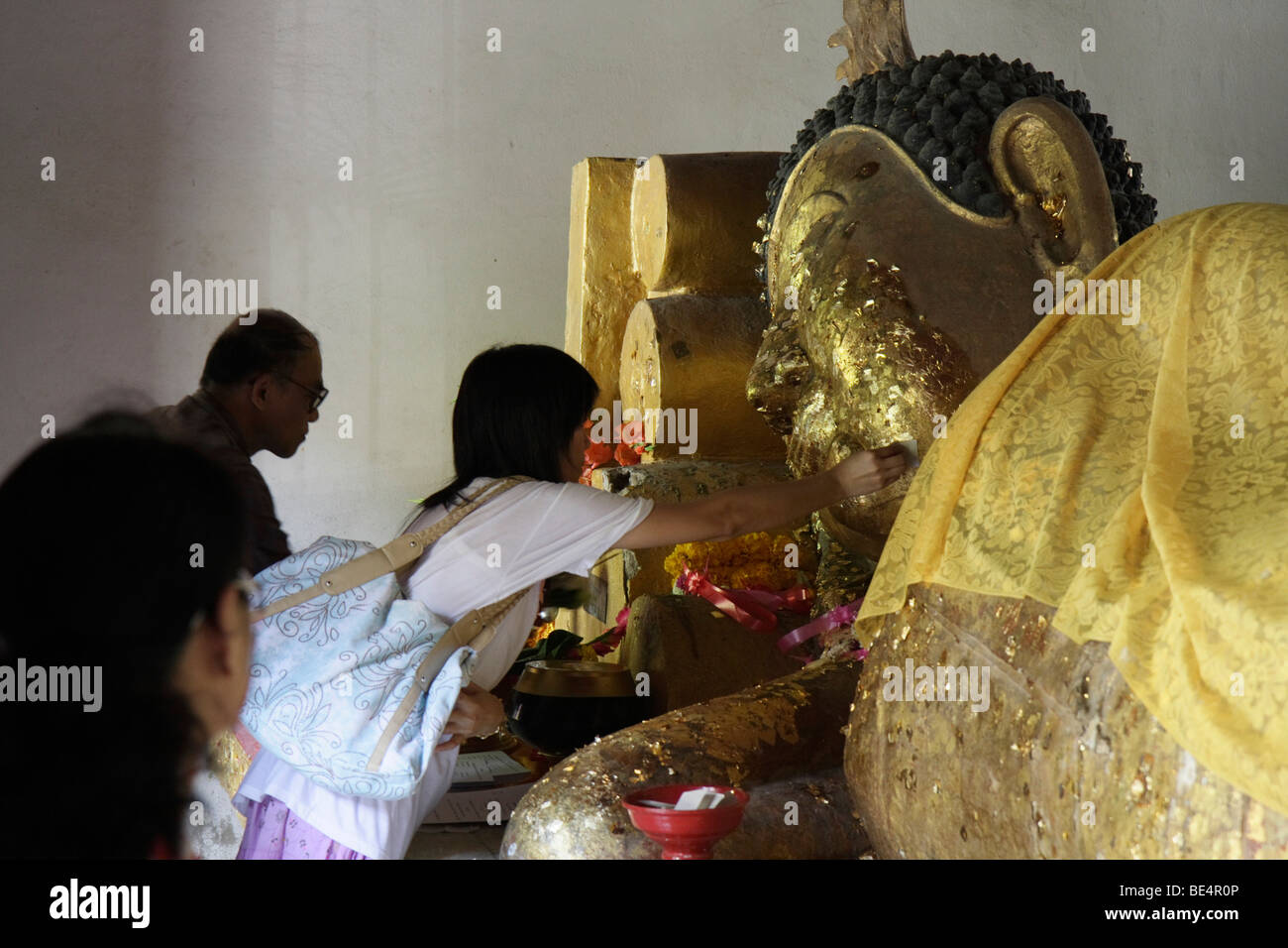 Buddhist sticking gold leaf on a recumbent statue of Buddha, Temple Wat Phra Sing, Chiang Mai, Northern Thailand, Thailand, Asia Stock Photo