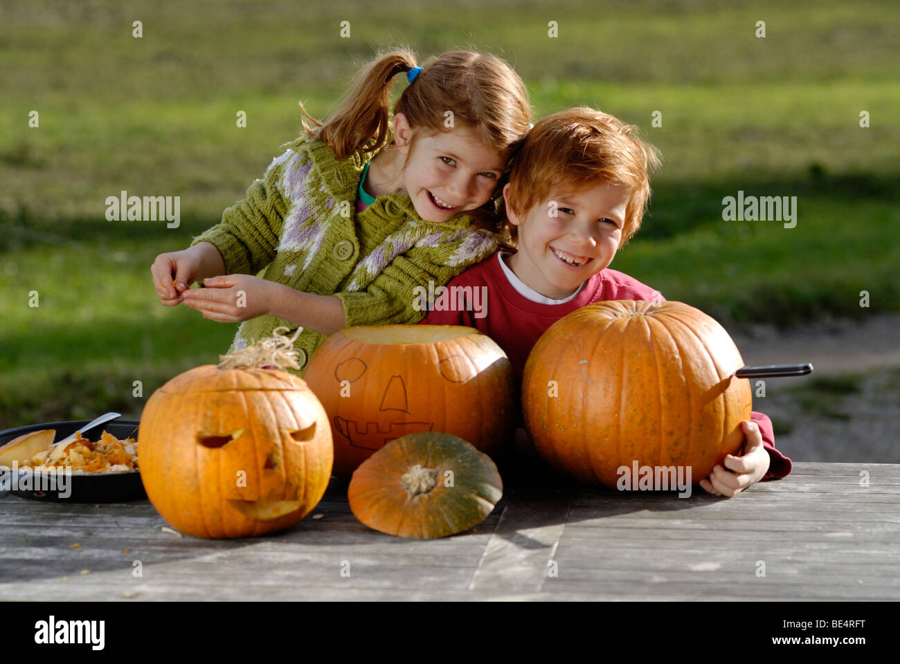 Two children carving pumpkins for Halloween decoration Stock Photo