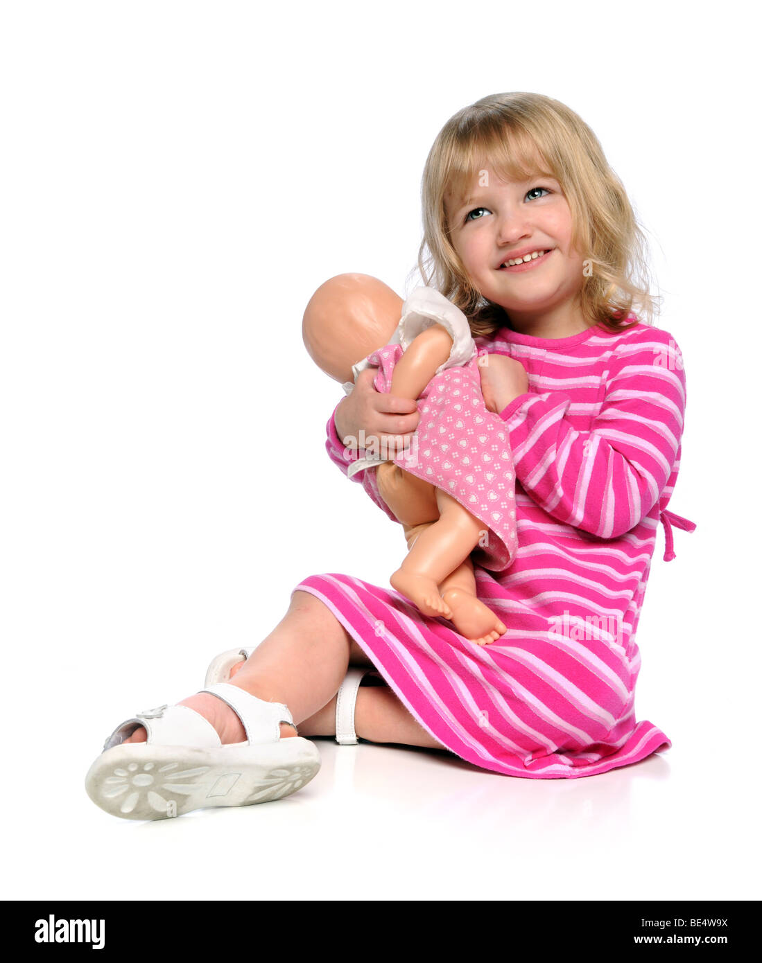 Young girl playing with doll isolated over white Stock Photo