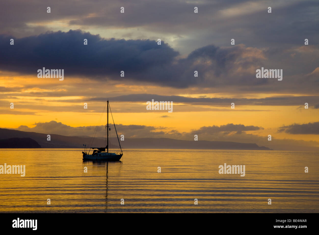 Yatch anchored in Browns Bay, Islandmagee, County Antrim at sunset Stock Photo