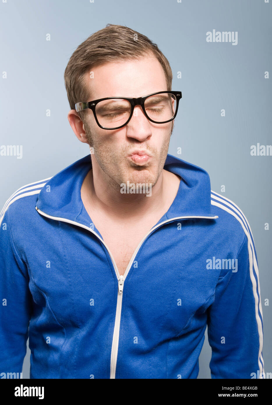 Young man posing in a retro style Adidas sport suit and looking down his  nose Stock Photo - Alamy