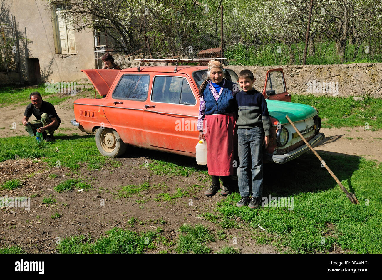 Armenian farmer family in Ltsen village with old Russian Saporoschetz car, Syunik region, Armenia, Asia Stock Photo