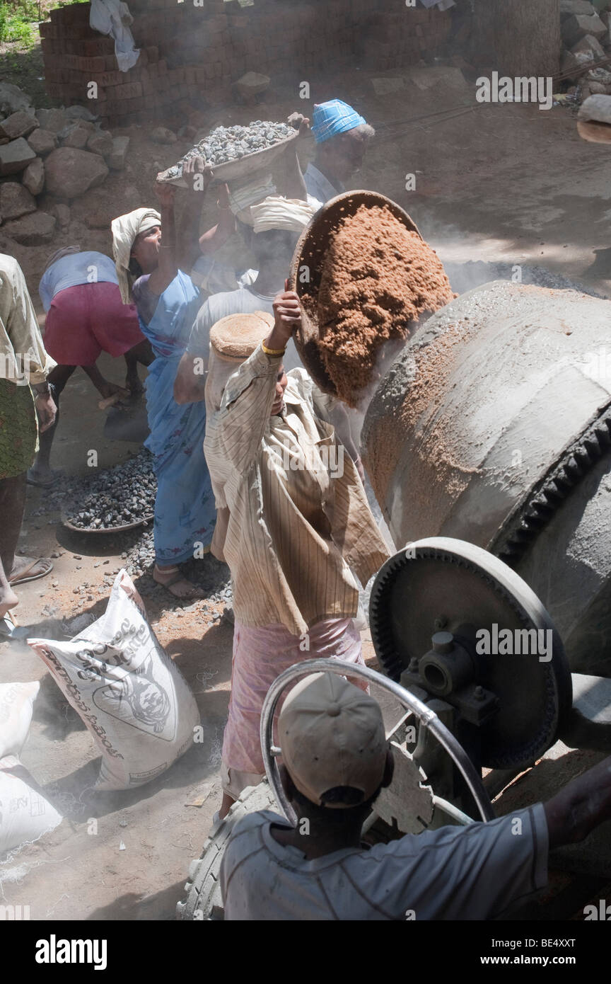 Indian construction workers mixing rock sand and cement to make concrete a building site. Andhra Pradesh, India Stock Photo