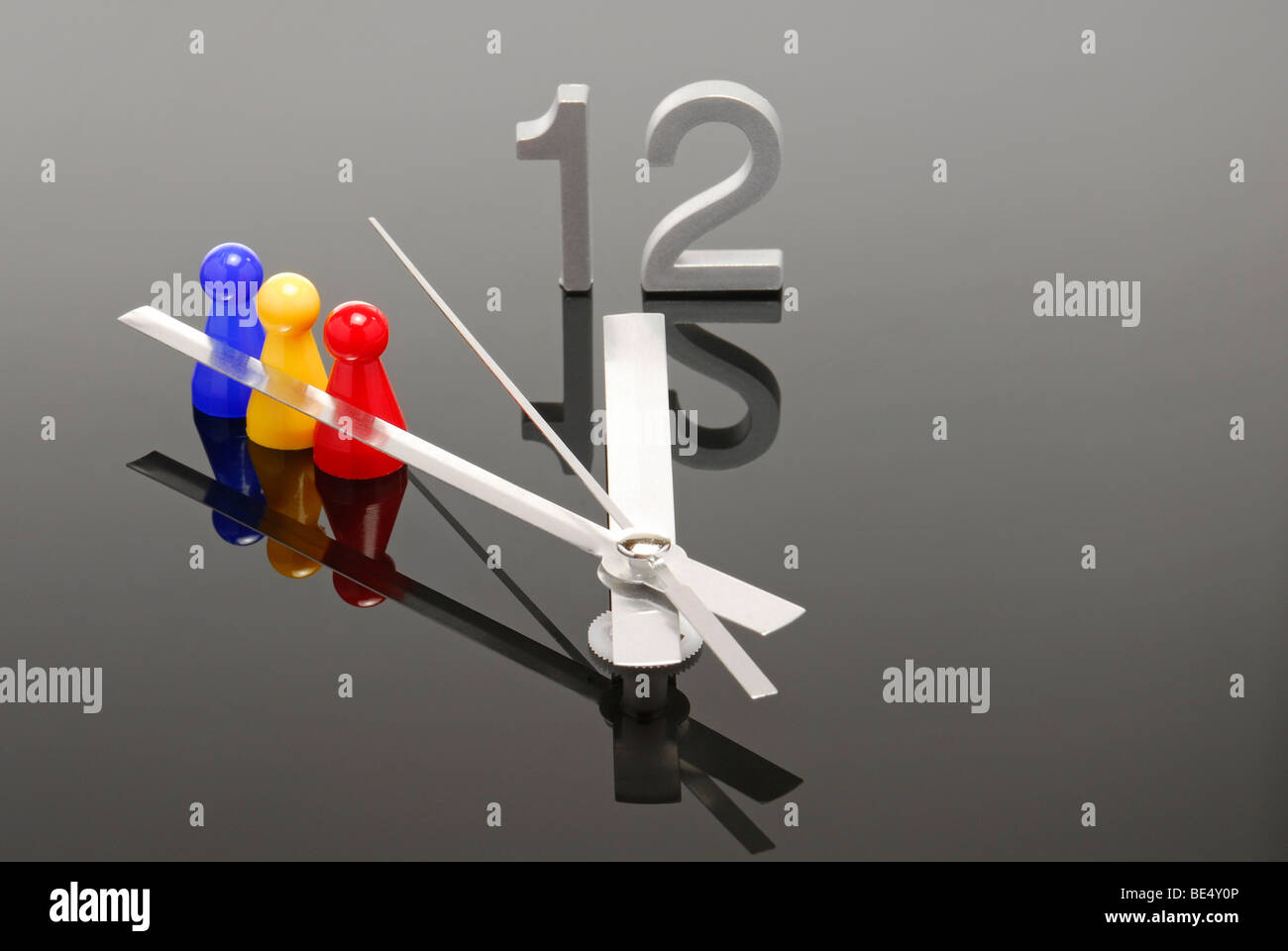 Game pieces with clock showing five to twelve, symbolic image for the team faces the crisis Stock Photo
