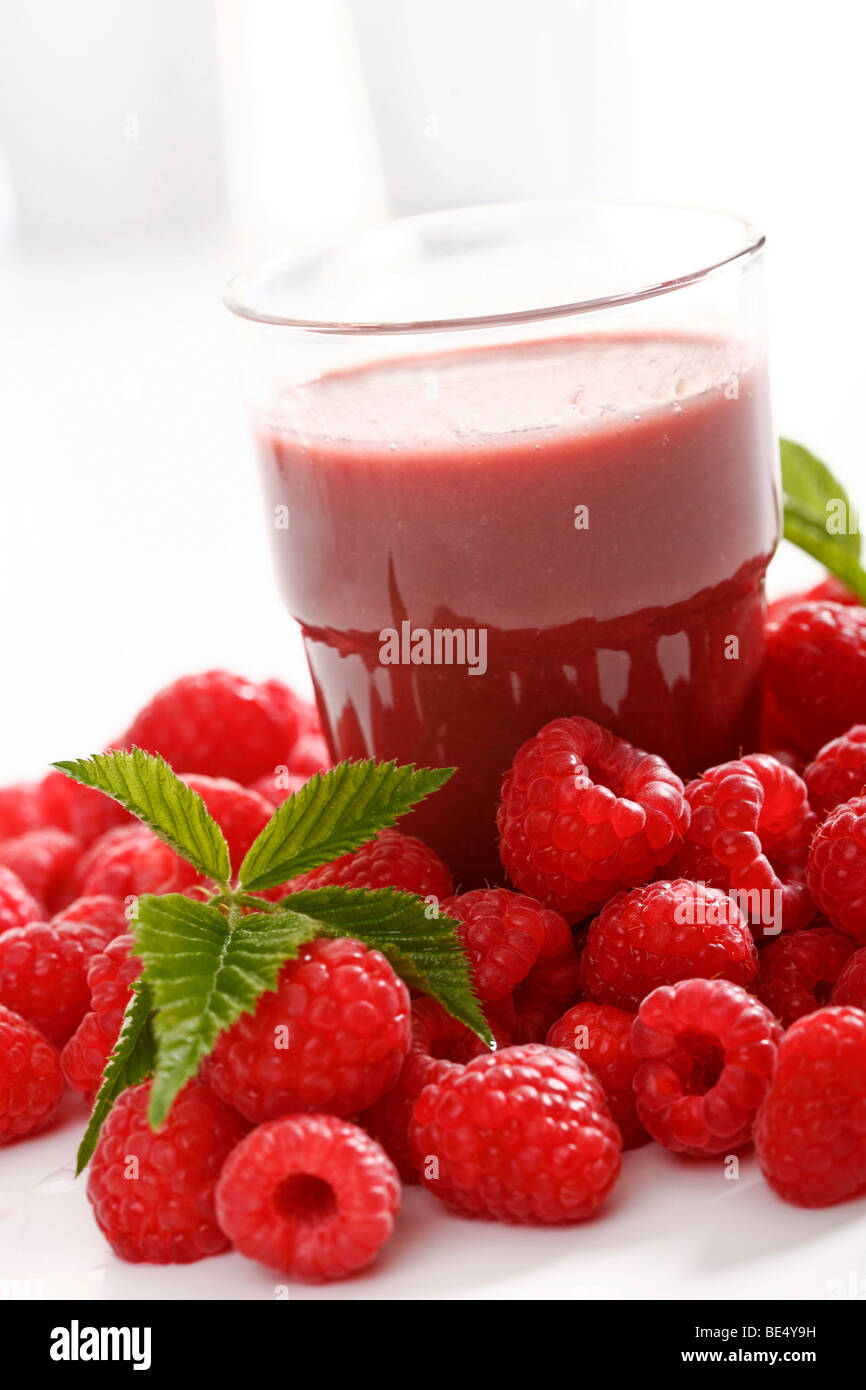 Glass of raspberry smoothie with fresh raspberries and raspberry leaves Stock Photo