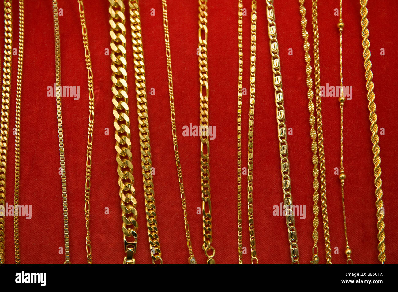 image of gold chain assortment on red velvet display board Stock ...