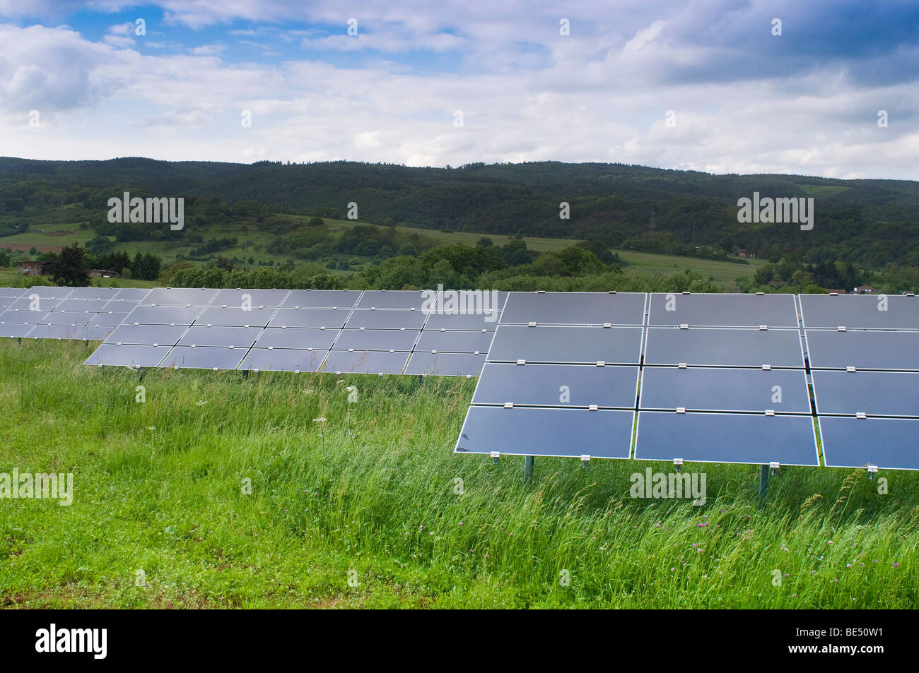 Photovoltaic, modules directed on different stands or racks on green meadow Stock Photo