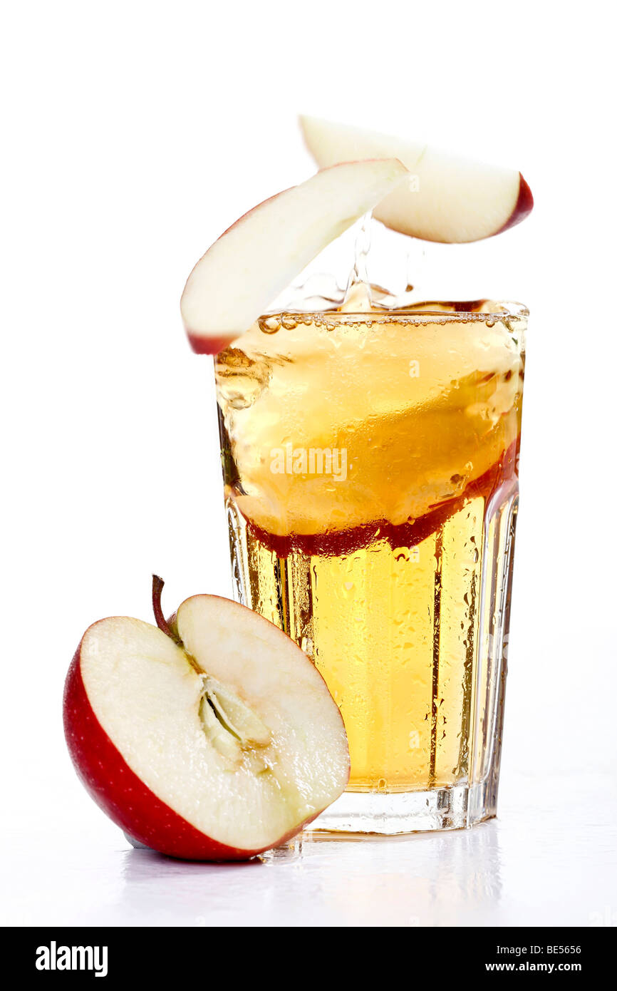 Apple pieces falling into a glass of apple juice Stock Photo