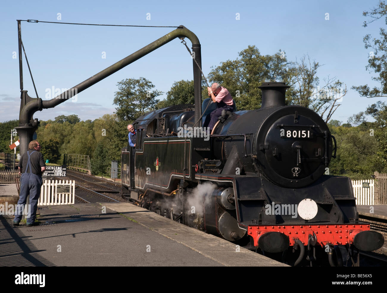 Three men re-filling a steam engine with water at Sheffield Park in Sussex, England. Stock Photo