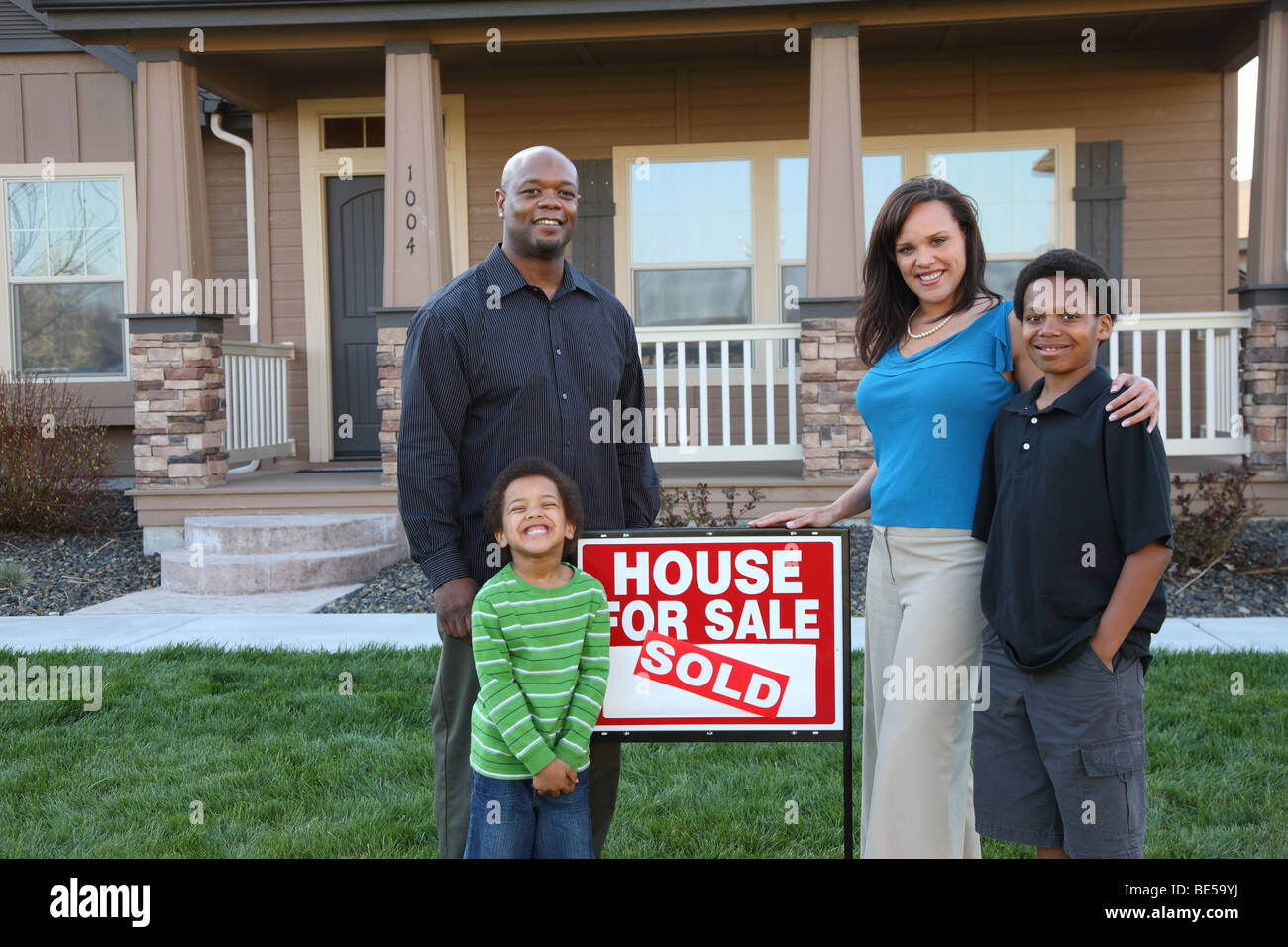 Family together in front of new home Stock Photo