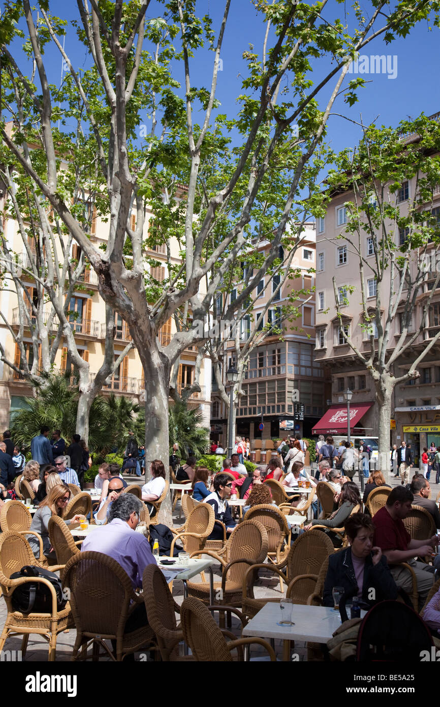 People sitting at cafe tables outdoors in plaza Palma Mallorca Spain Stock Photo