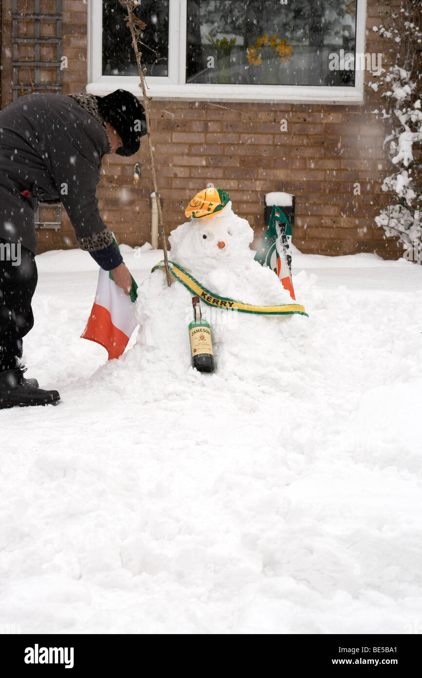 Woman building an Irish snowman with whiskey Stock Photo
