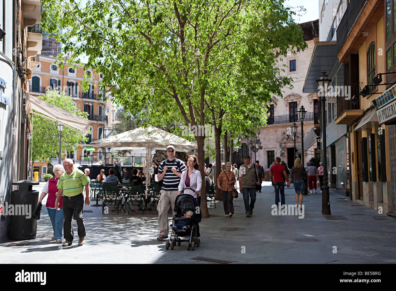 People walking in shopping street with couple pushing pram Palma Mallorca Spain Stock Photo