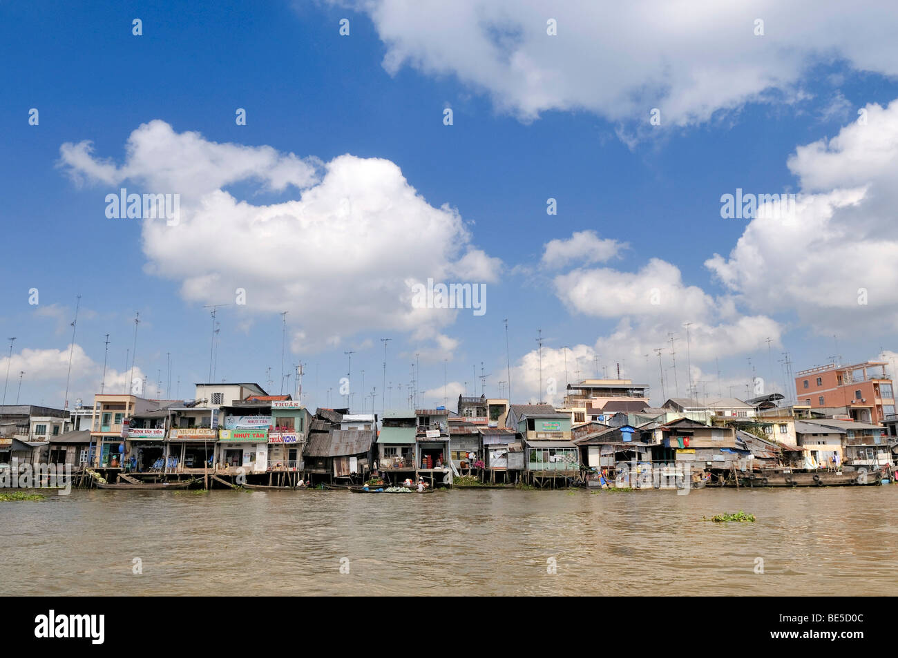 Residential dwellings and shops with numerous TV antennas on the roofs on the banks of the Mekong River, Mekong Delta, Vietnam, Stock Photo