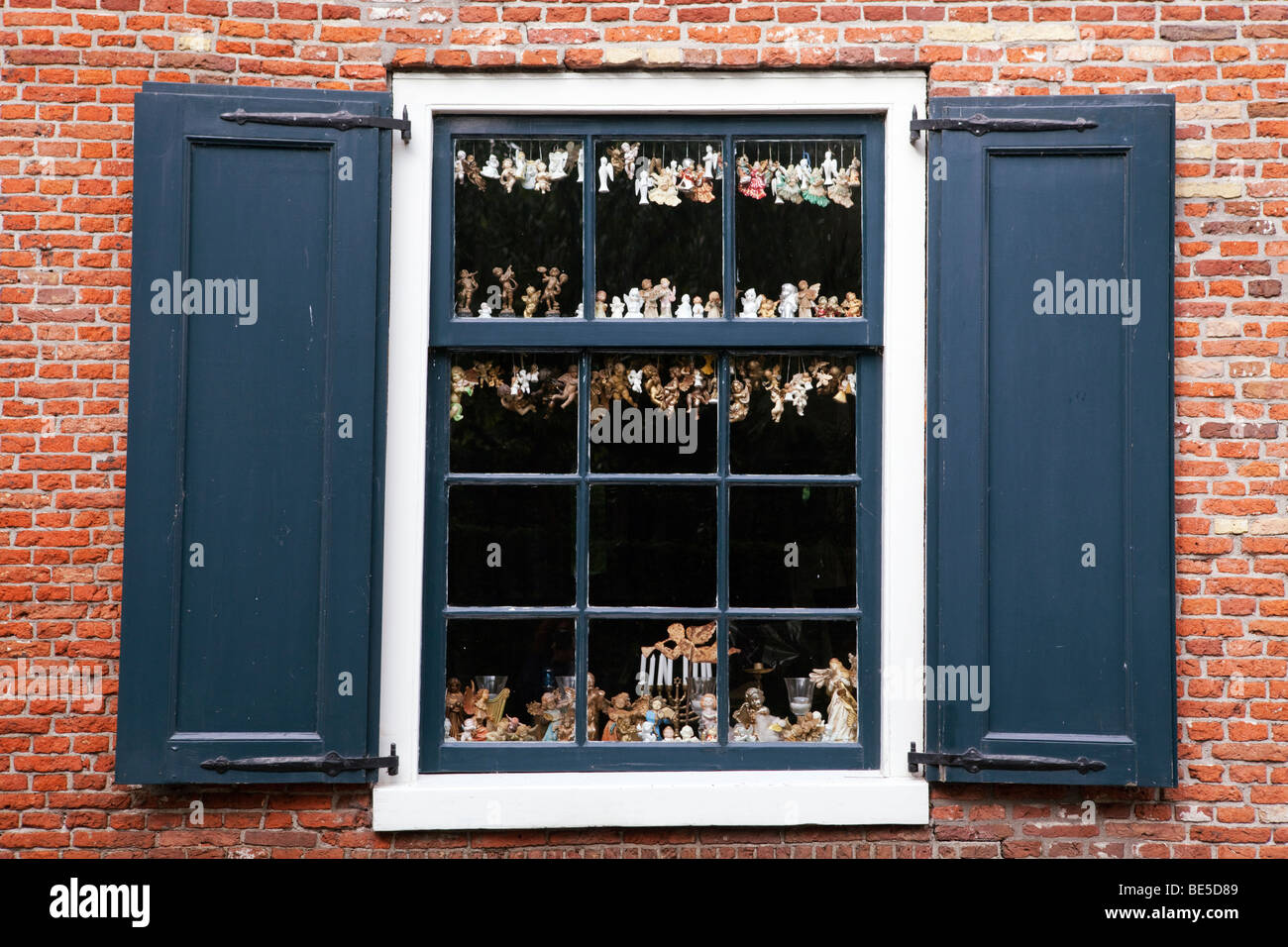Window with collection of little angels behind the glass Stock Photo