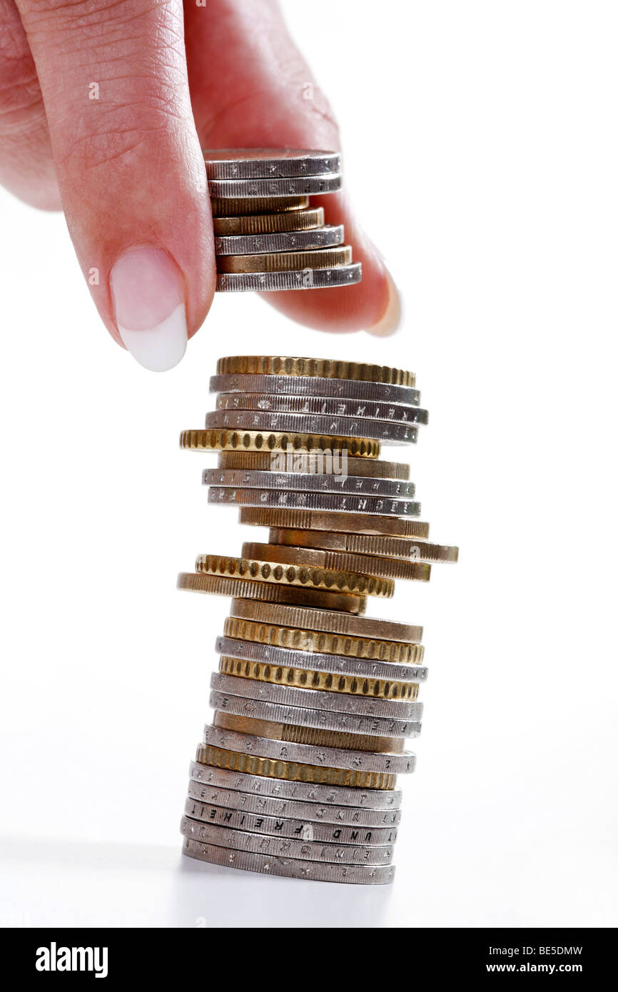 Hand taking coins from a pile Stock Photo