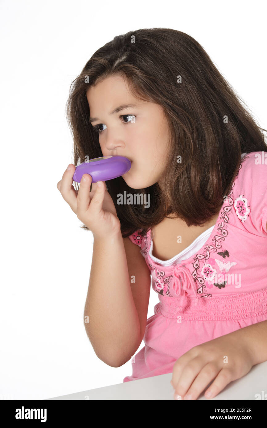 Cute Caucasian girl using an inhaler for Asthma Stock Photo
