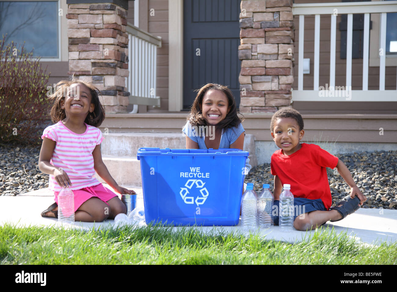 Three children with recycle bin Stock Photo
