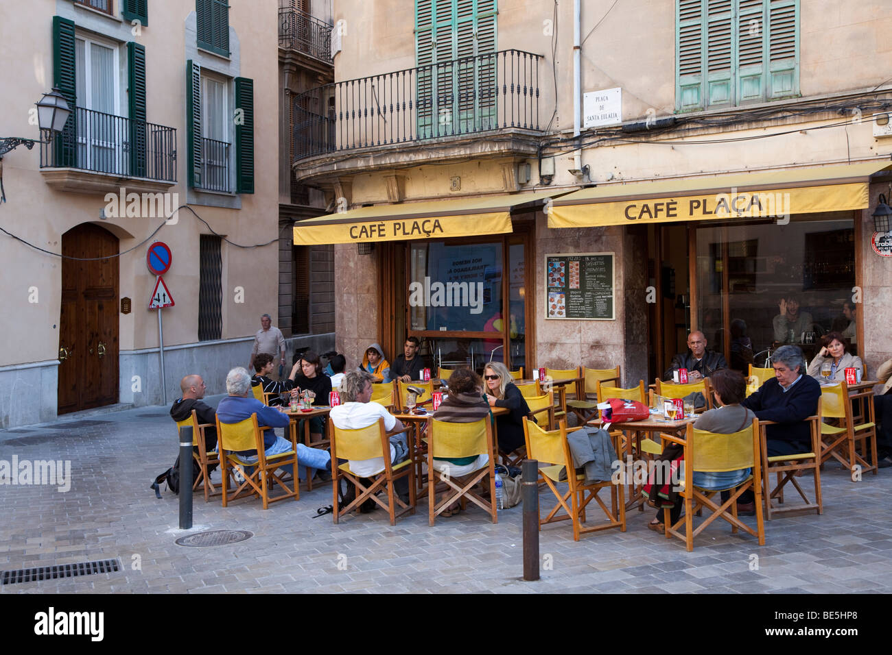 People sitting at cafe tables outdoors in plaza Palma Mallorca Spain Stock Photo