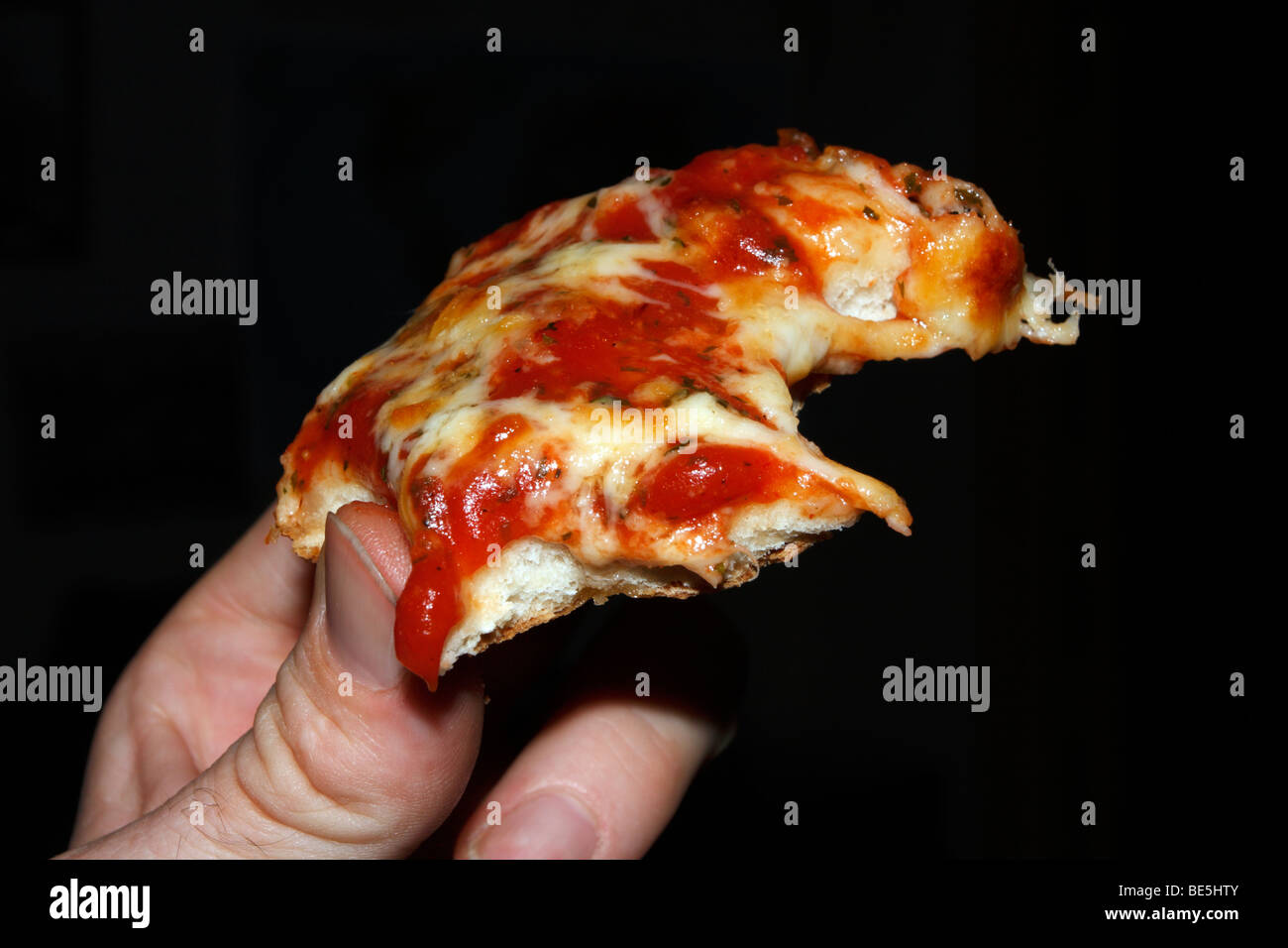 Freshly cooked pizza in hand. Stock Photo