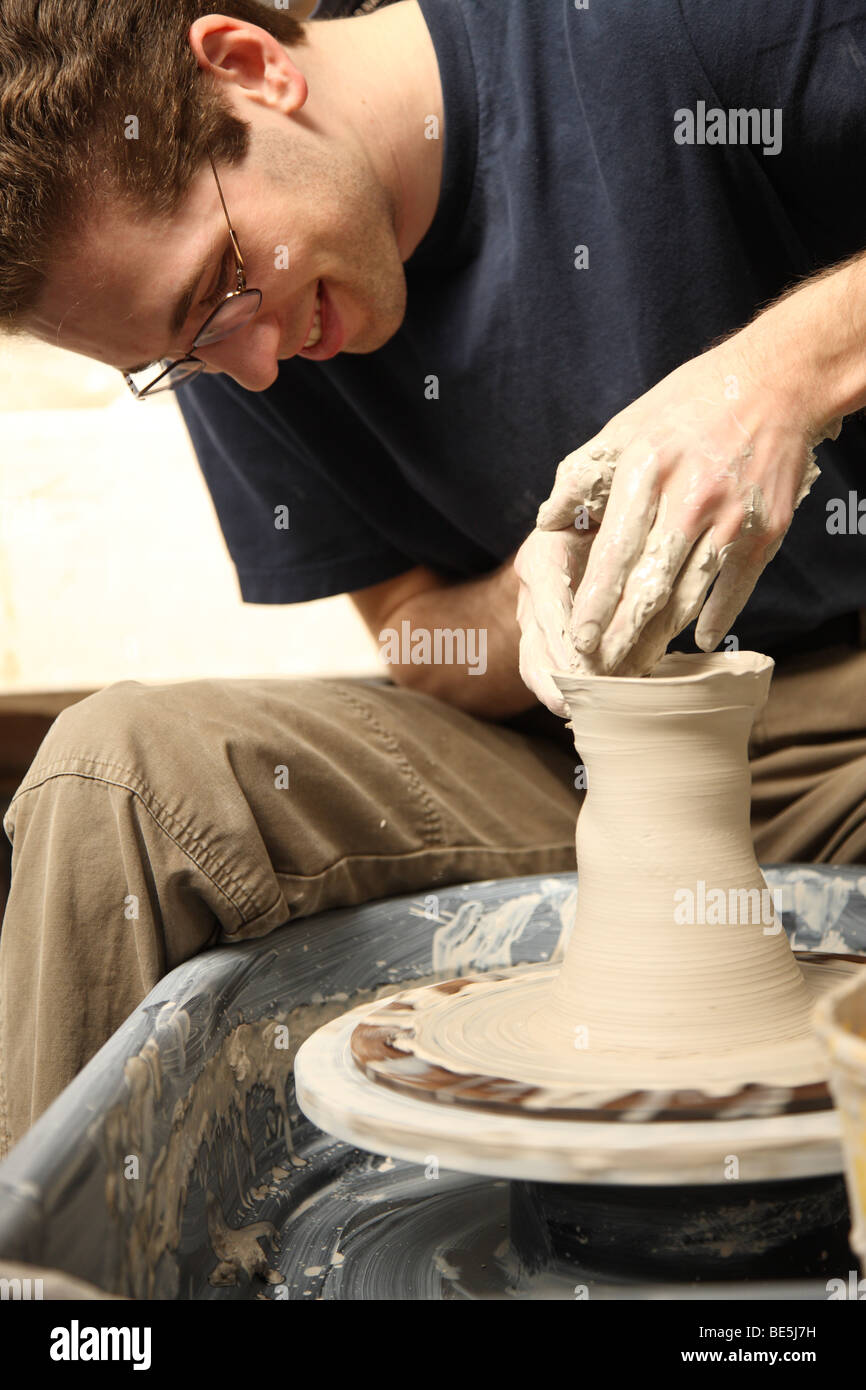 Young man making pot with pottery wheel Stock Photo