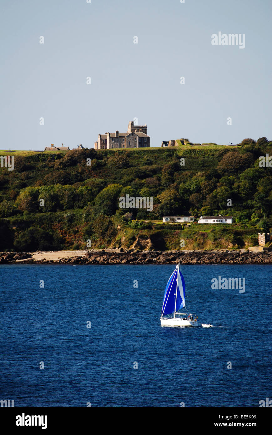 a yacht in falmouth bay cornwall, uk pendennis castle is in the background Stock Photo