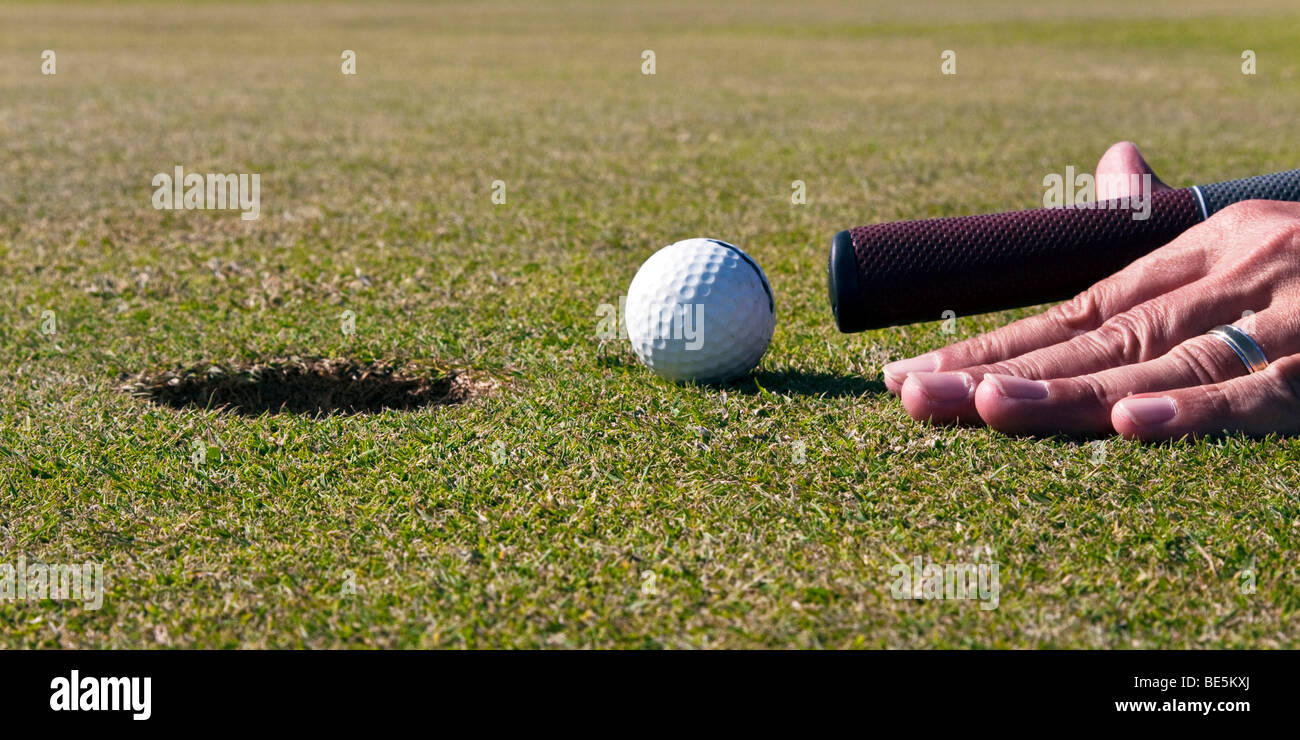 Putting differently, golf club is used as a billiard cue Stock Photo