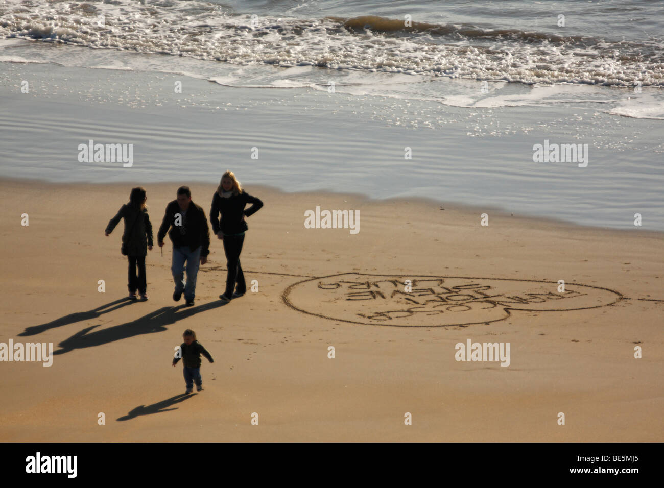 Family of Four Walking on a Sandy Beach Stock Photo - Alamy